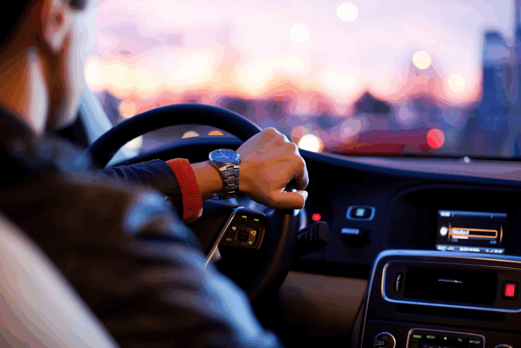 Man driving a car with his hand on the wheel