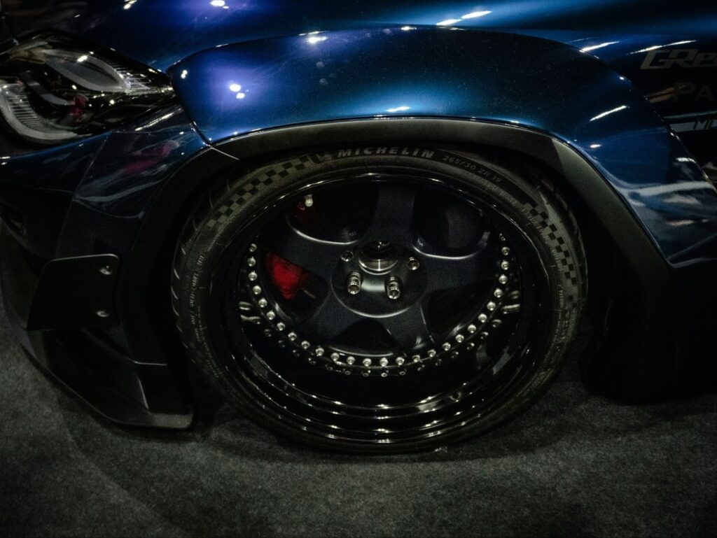Photo of a blue car with a focus on its wheel